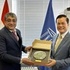 越南外交部副部长、联合国教科文组织国家委员会主任何金玉(右）向世界遗产委员会主席维沙尔·夏尔马送礼品。图自越通社