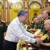  El presidente To Lam entrega una fotografía del Presidente Ho Chi Minh al mayor general Vo So, de 96 años, jefe del Comité de Enlace de Veteranos de la División 305 de Caballería Aérea y Fuerzas Especiales. (Fuente: VNA)