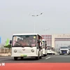 Los vehículos eléctricos que transportan a los turistas pasan por la línea divisoria del puente Bac Luan II (Foto: VNA)