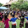 Los turistas interactúan con personas de etnia Thai en la Aldea de Cultura y Turismo de las Etnias Minoritarias. Foto de archivo: Periódico Tin Tuc (Noticias)