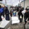 Refugiados palestinos reciben ayuda de la Agencia de Naciones Unidas para la población refugiada de Palestina en Oriente Próximo (UNRWA) en la ciudad de Rafah, Franja de Gaza. (Foto: AFP/VNA)