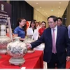 Фото: Премьер-министр Фам Минь Тьинь посещает стенд с продукцией под национальным брендом в 2022 году. (Фото: ВИА)