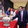 Фото: Премьер-министр Фам Минь Тьинь посещает стенд с продукцией под национальным брендом в 2022 году. (Фото: ВИА) 
