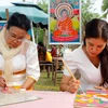 Хюинь Тхи Шок Кха и ее мать рисуют на стекле. (Фото: ВИА)