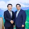 Премьер-министр Фам Минь Тьинь (справа) и заместитель премьер-министра и министр иностранных дел Лаоса Салеумксай Коммаситх на встрече в Ханое 5 июля (Фото: ВИA)