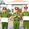 Pham Thanh Tâm, directeur adjoint du Département provincial de la sécurité publique de Long An remet les certificats de mérite du ministère de la Sécurité publique à deux policiers. Photo : VNA