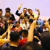 Brandissant le trophée de la Coupe du monde de billard carambole à trois bandes, Trân Duc Minh est entouré de ses fans. Photo : CTV/CVN