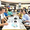 Des travailleurs explorent les besoins en recrutement lors d'un forum sur l'emploi à Long Biên. Photo: laodongthudo.vn