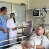 Jacques Ballout, chef du service de cardiologie de l’hôpital Pierre-Bérégovoy, et une stagiaire vietnamienne au chevet d’un patient français. Photo : VNA