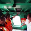 Les gardes-frontières du poste-frontière de Cat Lo vérifient le dispositif de surveillance des bateaux de pêche de la famille de Nguyên Thanh Loi dans le 12e quartier de la ville de Vung Tàu, avant son voyage en mer. Photo : VNA