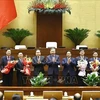 Le secrétaire général du Parti Tô Lâm (centre), le Premier ministre Pham Minh Chinh et le président de l’Assemblée nationale Trân Thanh Mân félicitent les personnels élus, nommés. Photo: VNA