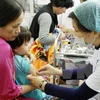 A vaccine shot is given to children. (Photo: VNA)
