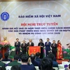 Prime Minister Nguyen Xuan Phuc presents emulation flag tothe Vietnam Social Security with the Government. (Photo: VietnamPlus)