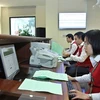 Staff at Hanoi Stock Exchange enter auction information (Photo: VNA)