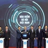 Prime Minister Nguyen Xuan Phuc and other delegates press the button to launch the “VssID - Digital Social Insurance” application (Photo: VNA)