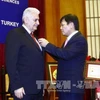 Insigne «Pour la cause des sciences sociales du Vietnam» au Premier ministre turc