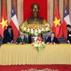 Президент Вьетнама Чан Дай Куанг и президент Чили Мишель Бачелет подписывают документ о сотрудничестве между двумя странами во время ее государственного визита во Вьетнам 9 ноября 2017 года. (Фото: Нгуен Зан/ВИА)