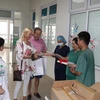 Британская пара была очень тронута и рада вновь встретиться с врачами и другим медперсоналом и подарила им книги. (Фото: PV/Vietnam+)