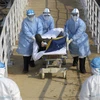 Медработники доставляют заболевших пневмонию, вызванной новым типом коронавируса на лечение в полевой госпиталь Горного Огня в Ухане, провинция Хубэй, Китай, 4 февраля 2020 года. (Фото: Синьхуа/ВИА)