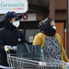 Люди носят защитные маски от острых респираторных инфекций COVID-19 в городе Казальпустерленго, Италия, 23 февраля 2020 года. (Фото: AFP/ВИА)
