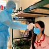 Проверка температуры пациента на карантине в Ханое (Фото: ВИА)