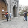 Посетители читают уведомление о приостановке работы туристического объекта. (Фото: Тхуи Зунг/ВИА)