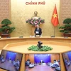 Премьер-министр Нгуен Суан Фук (в центре) выступает на телеконференции 10 апреля (Фото: ВИА) 