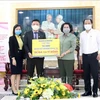 То Тхи Бить Чау (второй справа), председатель отделения Отечественного фронта Вьетнама города Хошимина, получает пожертвование от представителей бизнеса. (Фото: ВИА)