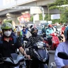Ханойские мотоциклисты укутываются в одежду, чтобы защитить себя от летней жары. (Фото: ВИА)