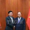 Премьер-министр Нгуен Суан Фук встречается со своим лаосским коллегой Тонглоном Сисулитом во время визита премьер-министра Лаосской Республики во Вьетнам 5 июля. (Фото: ВИА)
