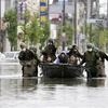 Военнослужащие Сил самообороны Японии эвакуируют жителей на лодке в Фукуоке (Фото: Киодо)