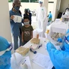 Медицинские работники проводят экспресс-тест на COVID-19 у людей, вернувшихся из районов эпидемии. (Фото: ВИА)