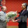 Посол Вьетнама в Германии Нгуен Минь Ву дарит цветы немецкому журналисту Хельмуту Капфенбергеру на церемонии открытия. (Фото: ВИА)