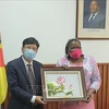 Посол Вьетнама в Мозамбике Ле Хыу Хоанг вручает картину министру иностранных дел Мозамбика Веронике Натаниэль. (Фото: ВИА)
