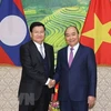 Премьер-министр Нгуен Суан Фук (справа) приветствует своего лаосского коллегу Тонглуна Сисулита (Фото: ВИА)