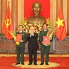 Генеральный секретарь ЦК КПВ, президент Нгуен Фу Чонг (в центре) вручает решения о повышении в должности двум заместителям министра обороны (Фото: ВИА)