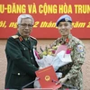 Заместитель министра обороны генерал-лейтенант Нгуен Тьи Винь вручает решение подполковнику Чан Дык Хыонг (Фото: ВИА)