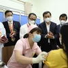 Заместитель министра здравоохранения Чан Ван Тхуан (второй справа) проверяет вакцинацию от COVIVAC на добровольце. (Фото: ВИА)