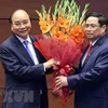 Премьер-министр Фам Минь Тьинь (справа) вручает цветы президенту страны Нгуен Суан Фуку и премьер-министру на период 2016-2021 годов. (Фото: Тхонг Нят/ВИА)