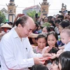 Президент Нгуен Суан Фук раздает подарки детям в общине Тыса, уезд Ламтхао, провинция Футхо (21 апреля 2021 г.). (Фото: ВИА)