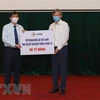 Министр здравоохранения Нгуен Тхань Лонг (слева) получает пожертвование от компании Vietnam Electricity (Фото: ВИА)