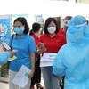 Проверяют медицинскую декларацию и температуру тела работников нефтегазовой отрасли перед входом в зону вакцинации 