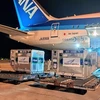Контейнеры с вакцинами из Японии во Вьетнам спускаются с самолета для транспортировки на склад хранения. (Фото: ВИА)