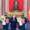Президент государства вручает решение о повышении в звании двум руководителям Министерства национальной обороны. (Фото: Тхонг Нят/ВИА)