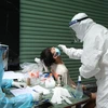 Медицинский персонал в районе Донгда берет пробы для тестирования на COVID-19. (Фото: Минь Кует / ВИА)