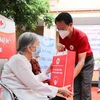Член Общества Красного Креста передает помощь пожилой женщине (Фото: ВИА)
