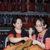 Женщина-монг учит свою дочь изготовлению традиционной вышивки и шитья этнической группы монг. (Фото: ВИА)