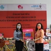 Элиза Фернандес Саенс, представитель структуры «ООН-женщины» во Вьетнаме (справа) передает пожертвования Зыонг Нгок Линь, директору Центра женщин и развития. (Фото: ООН-женщины)