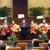 Председатель Национального собрания Выонг Динь Хюэ вручил решение и цветы группе молодых депутатов Национального собрания. (Фото: Зоан Тан / ВИА)