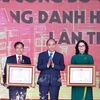 Президент Нгуен Суан Фук (в центре) вручает звание «Заслуженный учитель» 12 преподавателям сельскохозяйственной академии Вьетнама на церемонии 20 ноября (Фото: ВИA)